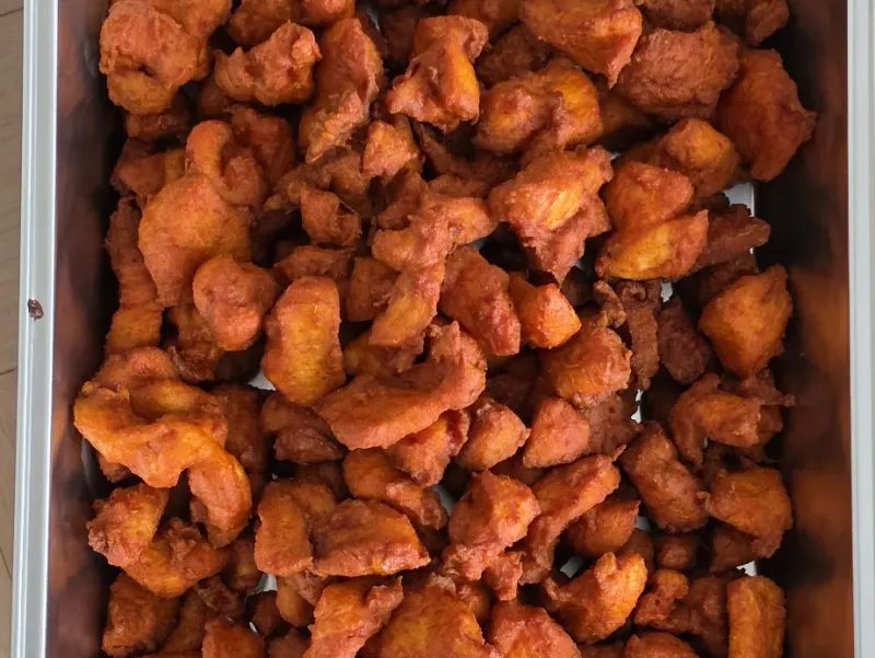 Een schaal versgebakken Chicken 65, krokant en dieprood met Zuid-Indiase kruiden