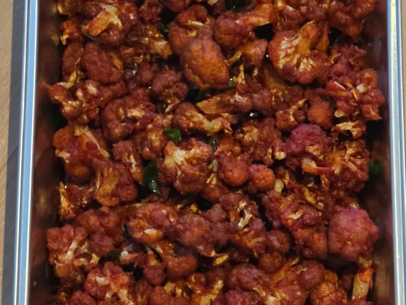 A tray of gobi 65, crisp red-spiced cauliflower with curry leaves