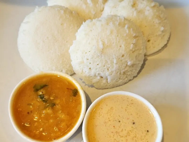 Idli met sambar en kokoschutney op een bord