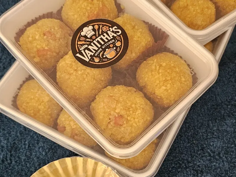 Laddu verpakt in bakjes met het Vanitha's Home Kitchen-label